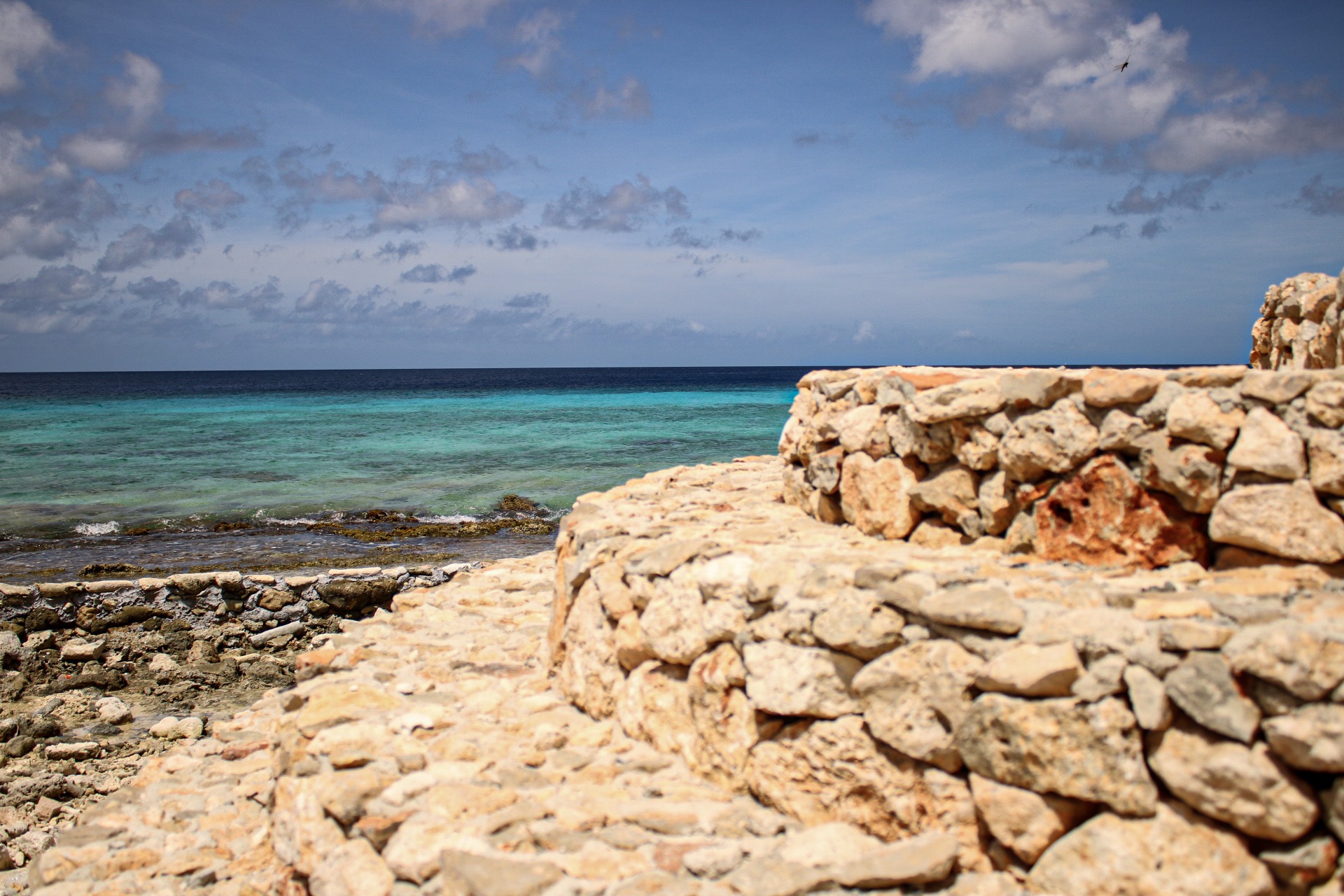 Private stone steps from a luxury Bonaire villa leading directly into the turquoise Caribbean Sea on a sunny day.